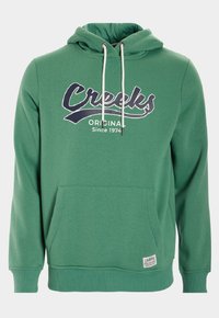 Sudadera verde de tejido suave con un bolsillo frontal, capucha con cordón y gráfico en azul marino que dice "Creeks Original Desde 1974".