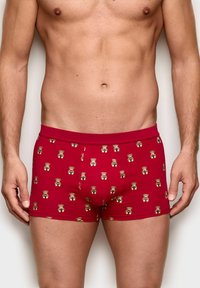 Red boxer shorts featuring a cartoon bear pattern. Made of smooth fabric with a snug fit and an elastic waistband.