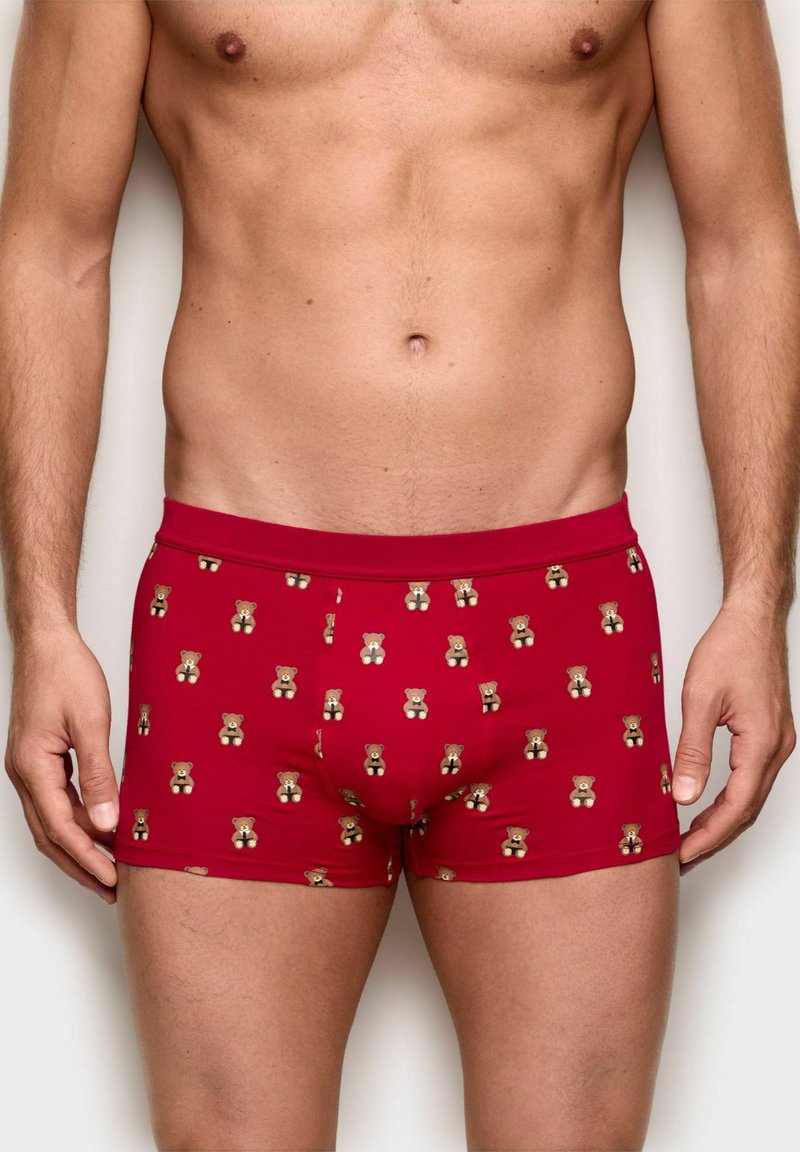 Red boxer shorts featuring a cartoon bear pattern. Made of smooth fabric with a snug fit and an elastic waistband.