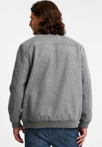 Grijze wollen mix jas met een gestructureerde oppervlakte, ribbelmanchetten en zoom. Heeft een eenvoudig ontwerp en een iets losse pasvorm.
