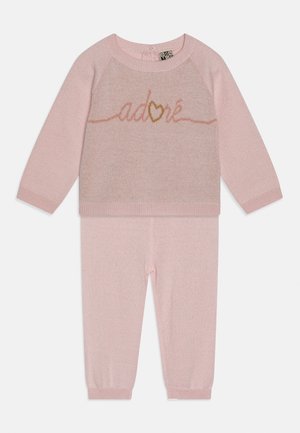 Rosa gestrickter Babypullover mit langen Ärmeln und Hose, Pullover zeigt das Wort "adoré" mit einem Herzen in der Mitte.