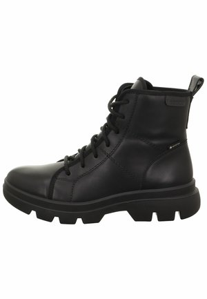Bottine en cuir noir, avec bout rond, tige texturée, fermeture à lacets, tirette et semelle en caoutchouc épaisse. Imperméable avec un détail de marque subtil.