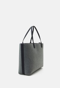 Sac fourre-tout rectangulaire gris avec détail de rayure verticale noire et fines bretelles en cuir noir sur fond blanc.