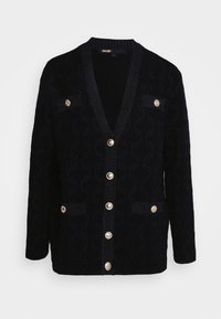 Cardigan en maille noire texturée avec col en V, manches longues, six boutons dorés sur le devant et quatre poches à rabat boutonnées.