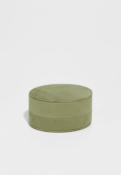 Cutie de depozitare rotundă, verde, din catifea, cu o textură netedă, formată din două segmente stivuite, având un design fără cusături și accente minime.