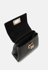 Sac à main en cuir noir avec une fermeture rectangulaire dorée, rabat ouvert révélant un intérieur noir spacieux avec une poche zippée.