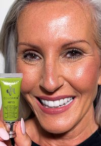 ColorFix matte vloeibare pigment in een groene tube, met waterdichte etikettering; close-up van een glimlachende vrouw met een frisse huid en heldere tanden.
