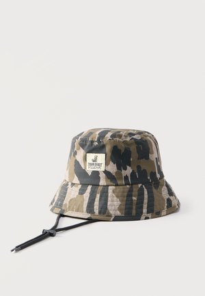 Sombrero tipo cubo con patrón de camuflaje, correa ajustable para la barbilla y parche rectangular con la inscripción "Tour Divot Malbon" en la parte frontal.