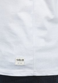 Witte katoenen t-shirt met een zachte textuur, met een vierkant geweven label op de onderkant links met "SOLID DENMARK EST. 1999."