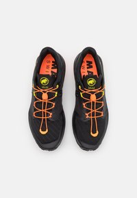 Czarne buty sportowe z siateczkowej tkaniny, pomarańczowymi sznurówkami i neonowo-żółtymi akcentami. Posiadają teksturowaną podeszwę i jasnopomarańczową wkładkę.