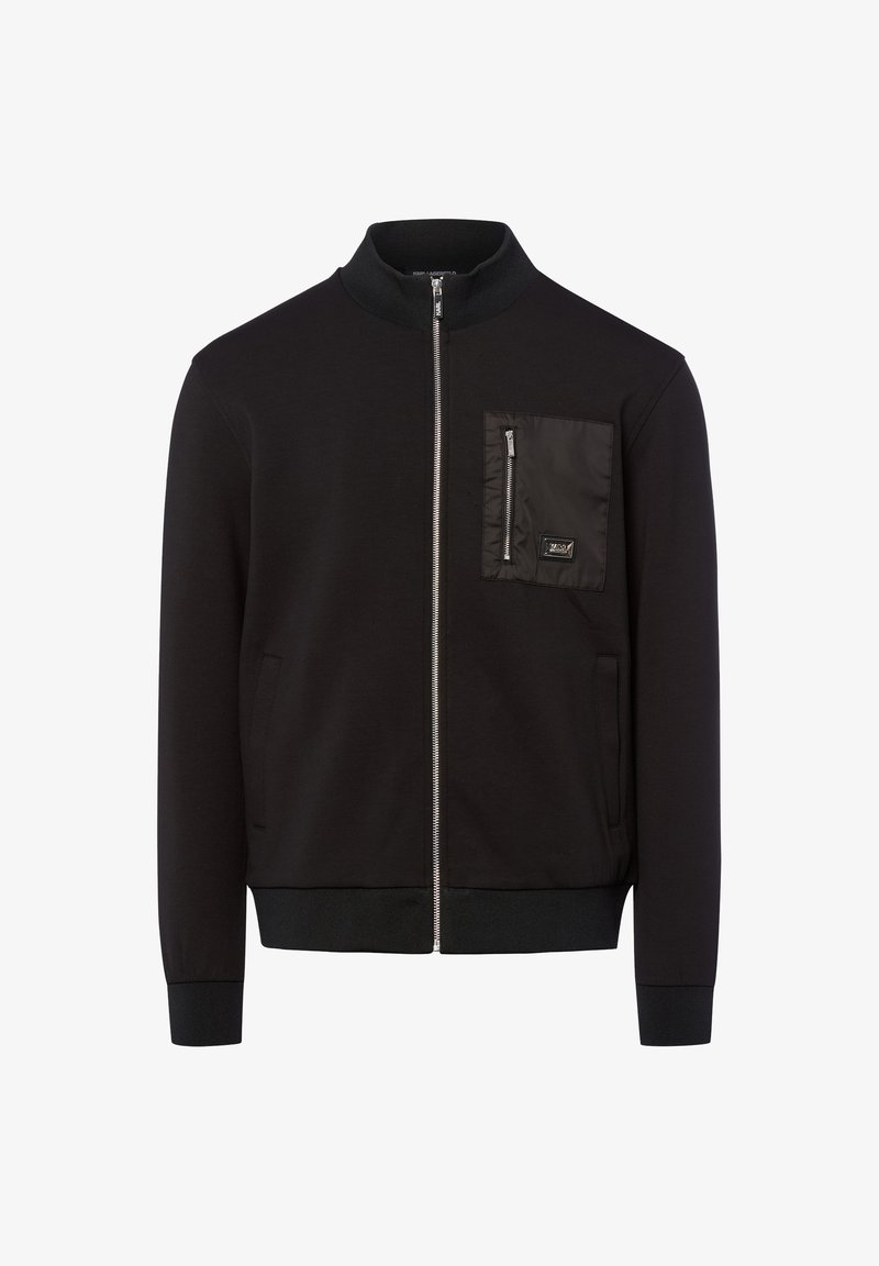 Zwarte zip-up jas met geribde kraag, manchetten en zoom, voorzien van een ritszak op de borst met een klein logo-patch.