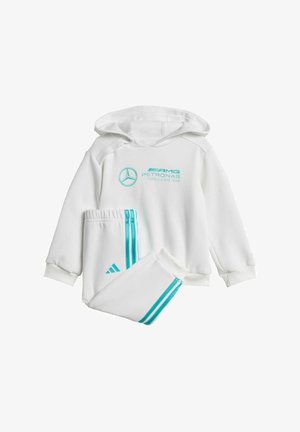 Biely set mikiny a teplákov, ktorý obsahuje tyrkysové pruhy a logá, vyrobený z mäkkej látky s voľným strihom a lemovanými manžetami.