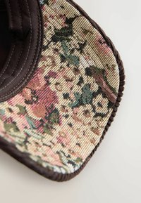 Brun hat med en tekstureret blomster mønsterstoffet, der har pink, grønne og sorte accenter på en lys baggrund.