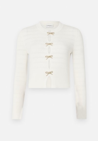 Weiße gestrickte, kurz geschnittene Strickjacke mit langen Ärmeln, strukturiertem Design und fünf goldenen Schleifenverschlüssen an der Vorderseite.