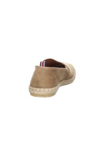 Espadrilles perforadas en tono marrón con suela de yute, que cuentan con un tacón estrecho y un acento de tela a rayas en la parte posterior. Textura suave.