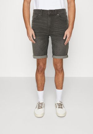 Dark gray denim shorts with rolled hems, five-pocket design, and a metal button closure, paired with white socks and sneakers.