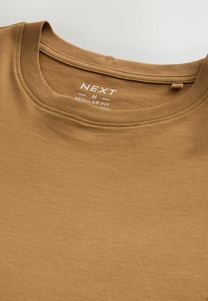 Brun bomulds T-shirt med rund halsudskæring og normal pasform. Har en label med teksten "NEXT" og størrelse "M" trykt indeni. Glat tekstur.