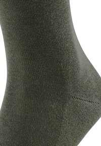 Groene gebreide sok met een gladde textuur, voorzien van een verstevigde teen en hiel, en een naadloos ontwerp voor comfort en pasvorm.