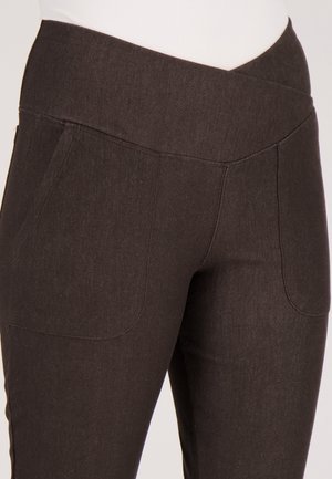 Bruine rekbare broek met een brede tailleband, voorzien van twee zakken aan de voorkant en een glad, gestructureerd stof. Close-upweergave benadrukt de stikdetails.