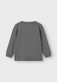 Sudadera gris de manga larga, con tejido texturizado, puños y dobladillo acanalados. Presenta una costura horizontal en la parte superior de la espalda. Diseño sencillo.