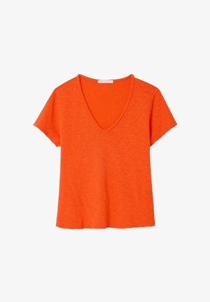Jaskrawo pomarańczowy, lekki T-shirt z krótkim rękawem, dekoltem w serek, wykończeniem surowej krawędzi i lekko skróconym krojem.