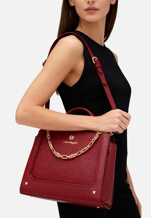 Borsa a tracolla in pelle rossa con texture, forma strutturata, catena dorata decorativa e logo. Include una tracolla regolabile.