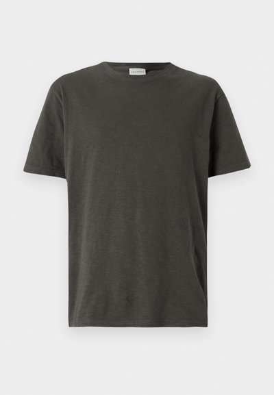 Sötét szürke, rövid ujjú póló, puha anyagból, kerek nyakkivágással és diszkrét logóval az alsó elülső részen.