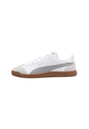 Zapatillas deportivas blancas con un acento de gamuza gris, punta redonda, suela plana de goma color marrón, y cordones tradicionales. Logo de Puma mostrado en el lateral.