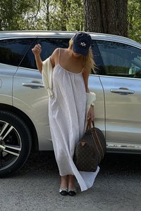 Balta dryžuota maksi suknelė su plonomis petnešėlėmis, derinama su šviesiu šaliu; nešiojama ruda raštuota sportinė kuprinė ir avint juodus baleriškus batelius.