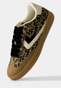 Leopard-print sneaker with beige and black accents, suede and mesh materials, flat black laces, and a gum rubber sole.
