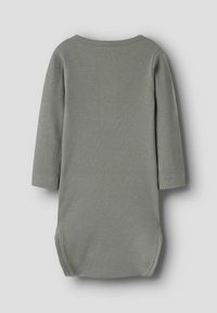 Pika, pika, halli ribiga hall beebivoodi, millel on ümmargune kaelus ja nööbid kubemes, nähtud tagant ühtlasel taustal.