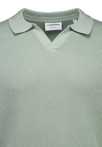 Light green knitted pullover with a V-neck and a folded collar, featuring a ribbed texture and a relaxed fit design.