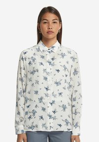 Långärmad knäppskjorta i vitt tyg med blå blommönster, med klassisk krage och avslappnad passform.