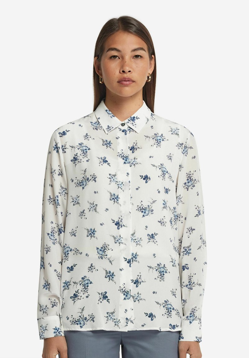 Långärmad knäppskjorta i vitt tyg med blå blommönster, med klassisk krage och avslappnad passform.