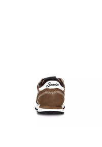 Sneaker in suede marrone con dettagli bianchi, linguetta nera sul tallone e cuciture zigzag. La vista posteriore mostra il marchio sul tallone e una superficie testurizzata.