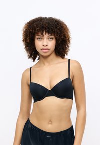 Zwarte bh met beugel van gladde stof, met verstelbare schouderbandjes en een getailleerd ontwerp. Eenvoudig en elegant zonder zichtbare patronen.