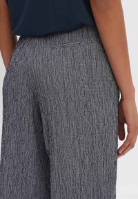 Grå texturerade vida byxor med ett subtilt randigt mönster, som har en enkel bakficka och en bekväm midja.