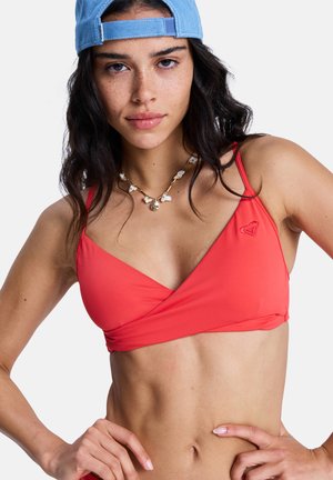 Haut de bikini rouge corail avec un design enveloppant, des bretelles fines réglables et un petit logo sur le côté gauche. Texture de tissu lisse.