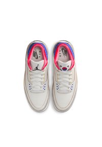 Sneakers bianchi in pelle con colletto imbottito blu e rosa, dettagli perforati e accenti blu. Presentano un logo e un design del paese sulla linguetta.