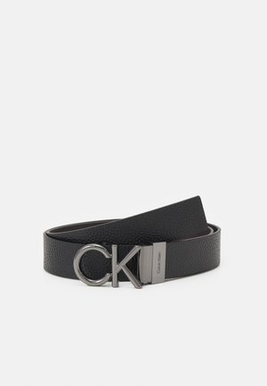 Cintura in pelle nera con una finitura testurizzata, dotata di una fibbia con logo CK in cromo e un accento hardware rettangolare in tono argento.