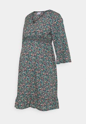Vestido premamá floral con pequeñas flores rosas, azules y blancas, escote en V, mangas tres cuartos, cintura elástica y bajo con volantes.