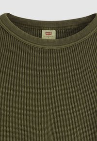 Olijfgroene geribbelde shirt met lange mouwen, voorzien van een ronde halslijn en een label met "Levi's" in de kraag.