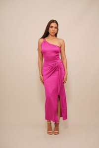 Eén-schouder magenta satijnen jurk met zijdelingse ruches, een split en gouden hardware accenten. Gladde textuur, halverwege de kuit.