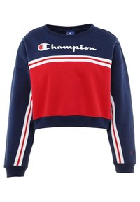 Námořnická modrá zkrácená mikina s červeným panelem, bílými pruhy a logem "Champion" v bílé barvě na hrudi. Materiál z bavlněné směsi.