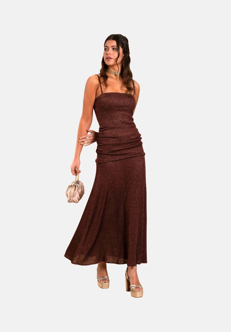 Maxikleid aus tiefburgunderfarbener, metallisch schimmernder Stoffqualität. Verfügt über ein tailliertes Oberteil, dünne Träger und einen ausgestellt geschnittenen Saum. Kombiniert mit einer leichten Clutch.