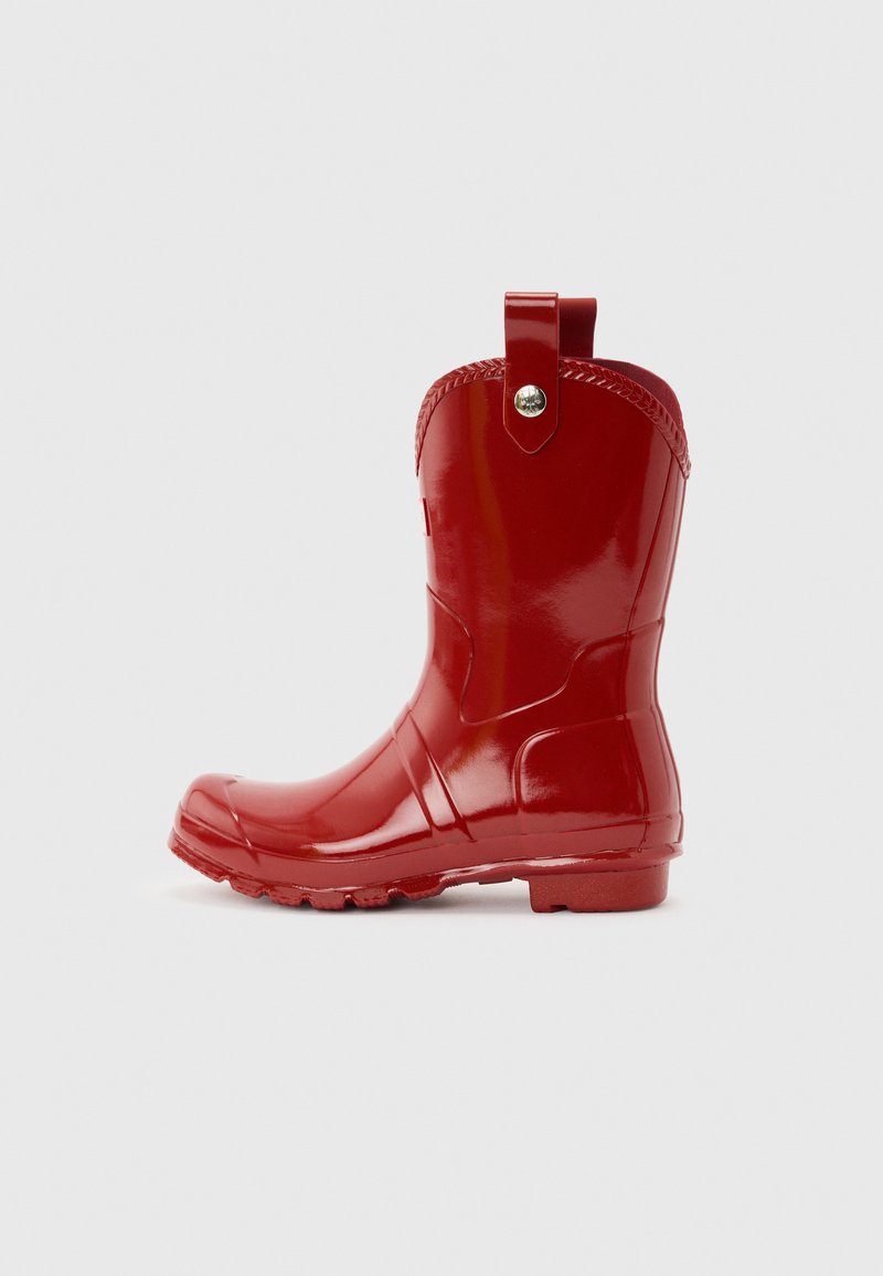 Γυαλιστερή κόκκινη λαστιχένια βροχερή μπότα μήκους μέχρι τη μέση της γάμπας, με ταινία έλξης και υφή σόλας, εμφανιζόμενη από πλάγια όψη σε ουδέτερο φόντο.