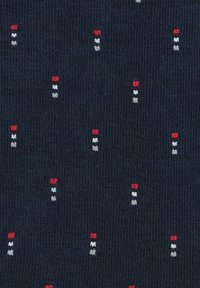 Granatowy materiał o teksturowanym wzorze dzianiny, z małymi pionowymi kropkami w kolorze czerwonym, białym i szarym równomiernie rozmieszczonymi w całej powierzchni.