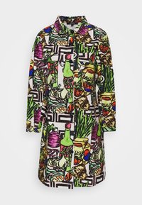 Kleurrijke button-up jas met een grafisch patroon van flessen, groenten en loof in levendige groene, paarse en rode tinten op een witte achtergrond.