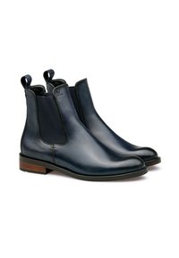 Bottines Chelsea en cuir marine avec panneaux latéraux élastiques, bout rond et tires. Semelle en bois et caoutchouc robuste, texture lisse avec un minimum de coutures.
