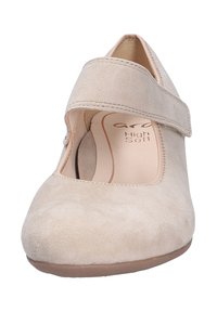 Beige suede Mary Jane shoes with a wide strap across the foot, round toe, and cushioned insole for comfort. Smooth, textured surface.